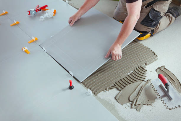 Professional tiler installing new tiles on the floor.